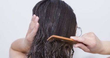 woman combing her hair with a wooden comb