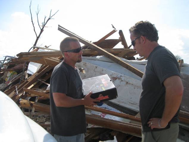 two men talking in the wreckage of a destroyed home