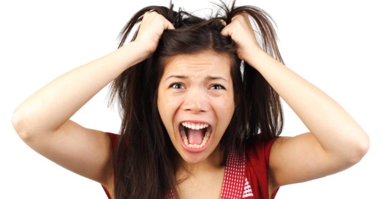 woman pulling her hair out from stress due to the holidays