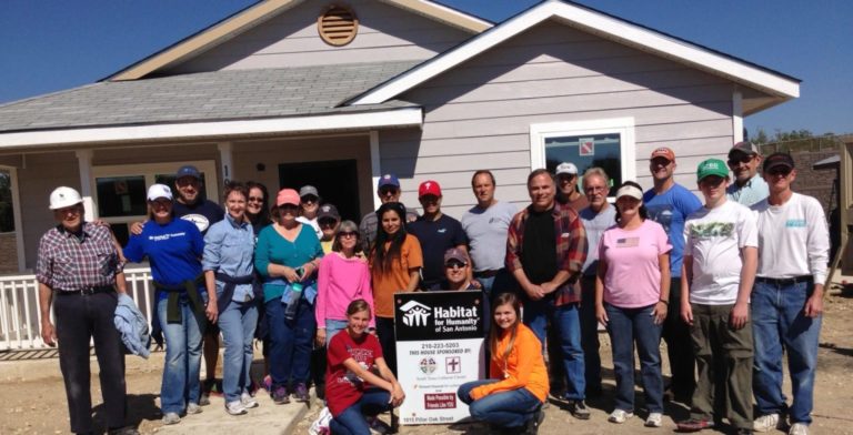 kinetico team with a hose they helped build for habitat for humanity