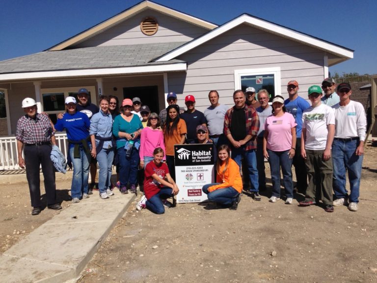 kinetico team with a hose they helped build for habitat for humanity