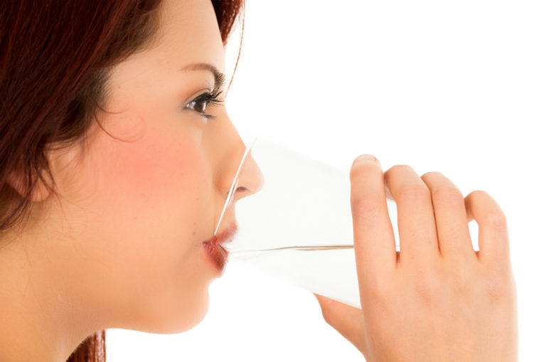 woman drinking from a glass of water