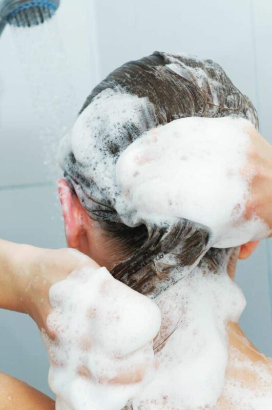 lady using shampoo on her hair making it very soapy