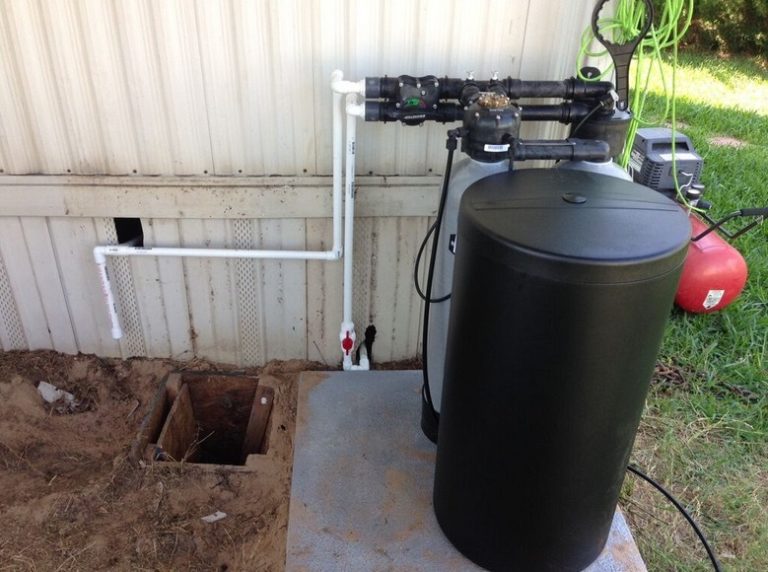 kinetico water softener installed on the outside of garage