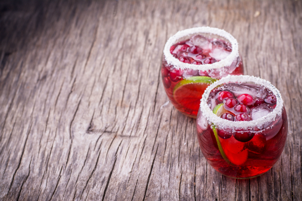 two margaritas ready to be drank. with cranberry juice and lime