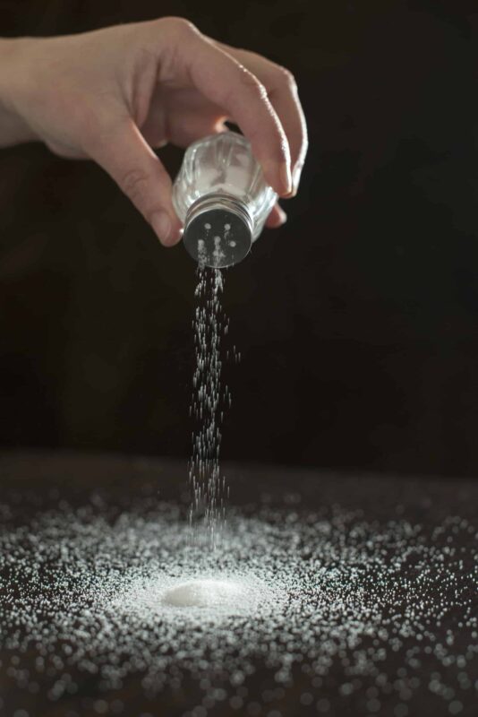 granulated table salt being poured out onto a table