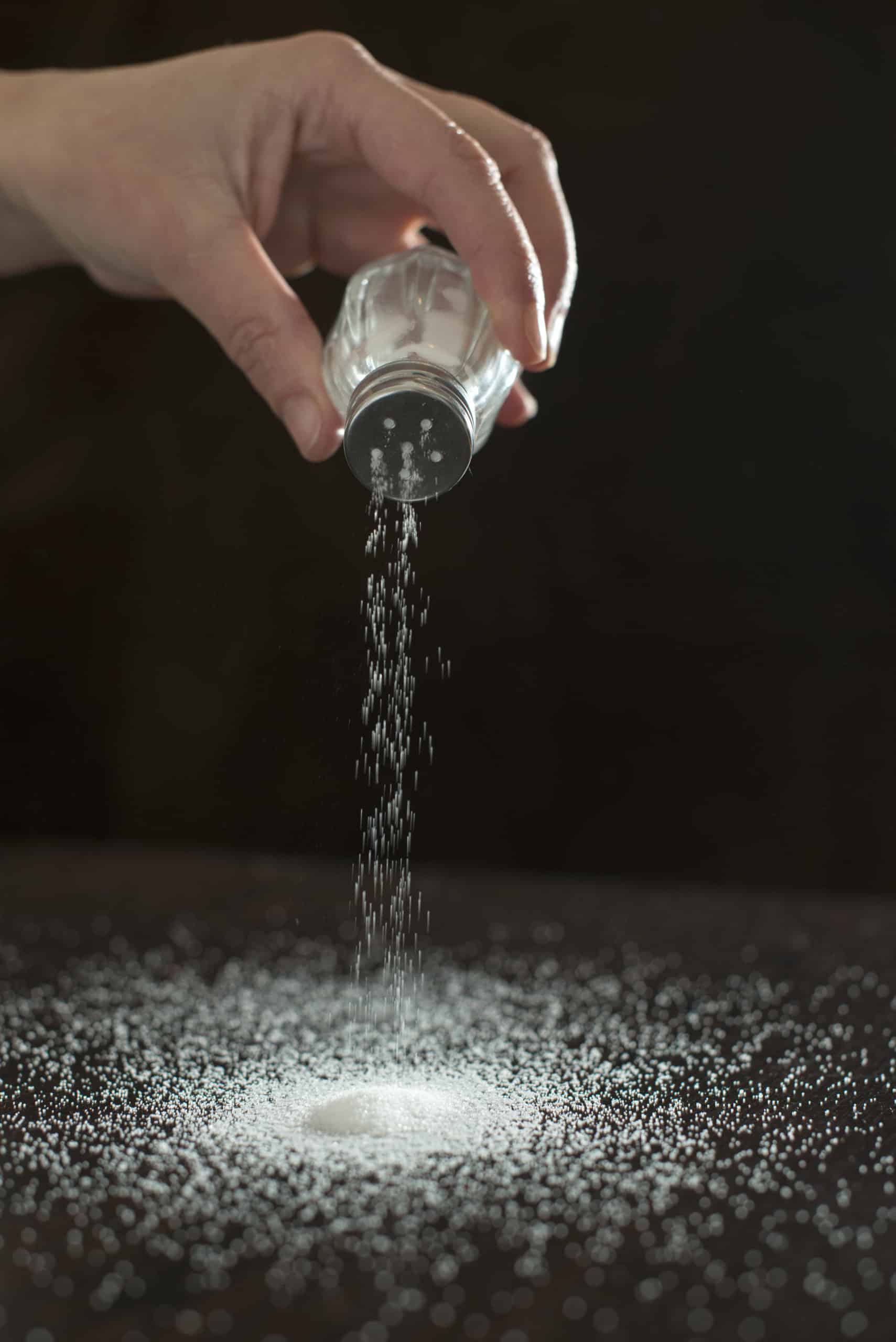 granulated table salt being poured out onto a table