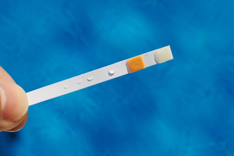chlorine test strip being used in a san antonio pool