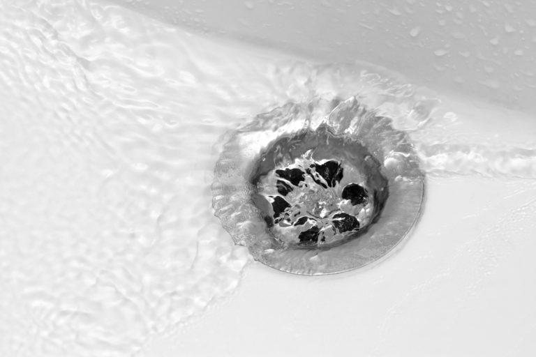 water going down a drain of a kitchen sink