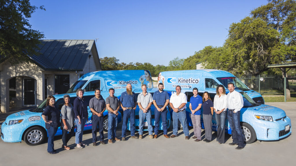the Kinetico San Antonio team standing in front of the official van