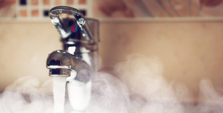 steam rising up as hot water pours from a sink faucet